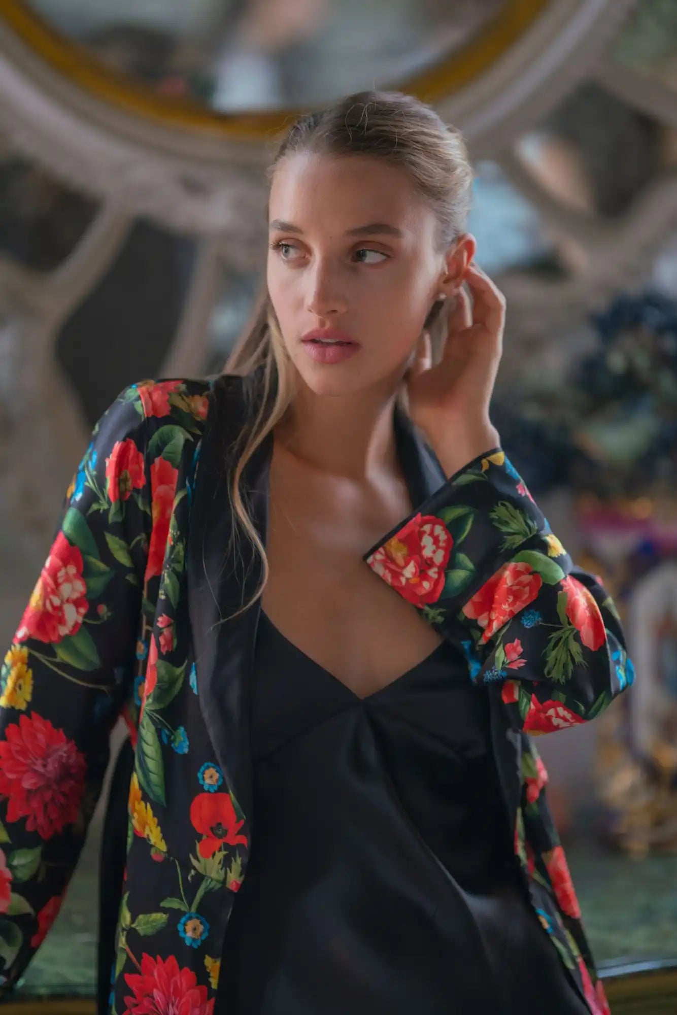 A floral print jacket worn over a black top.